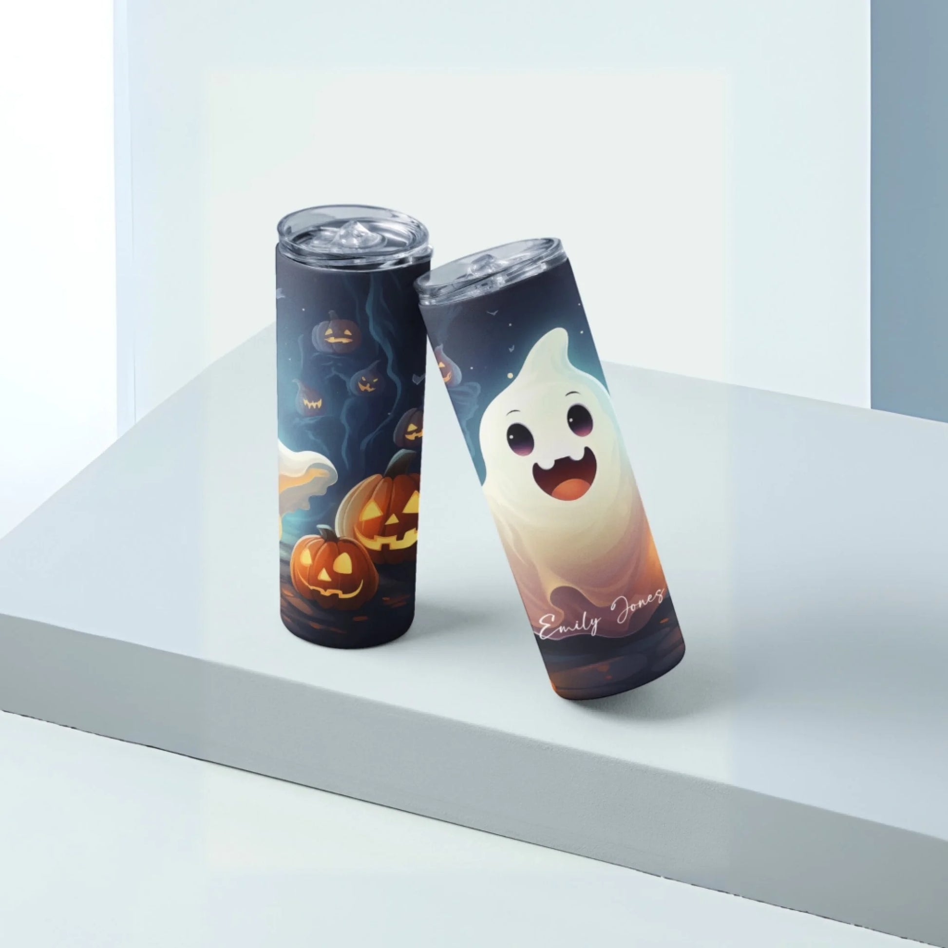 A tall Halloween tumbler sits on a light surface, featuring a smiling ghost and customized with “Emily Jones.” This is the Ghost Personalized 20oz Skinny Tumbler – Halloween Cup – Custom Name.